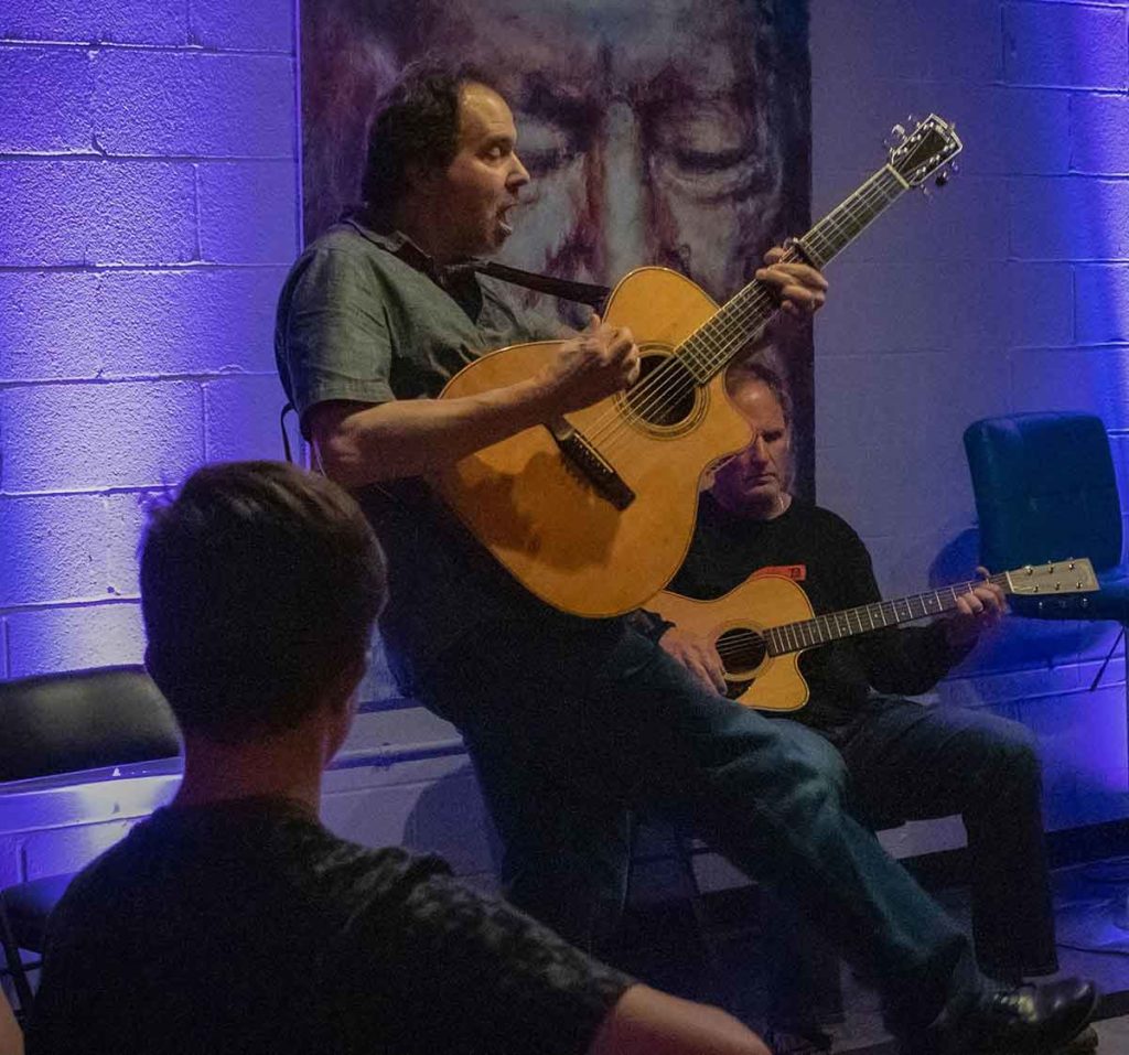 Dave Isaacs jamming on an acoustic guitar