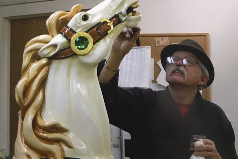 artist painting carousel horse