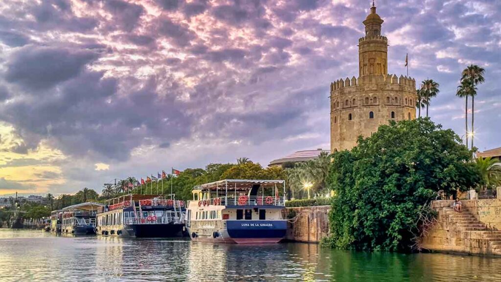 waterfront boats at Torre del Oro, millitary watch tower on Guadalquivir River in Seville Spain