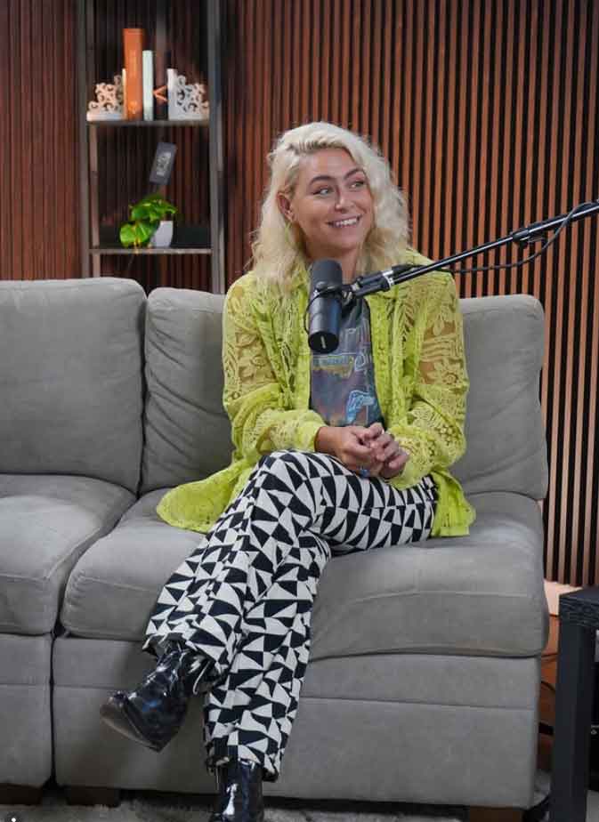 Singer-songwriter Emma Zinck doing an interview in front of a mic, sitting on a gray couch.