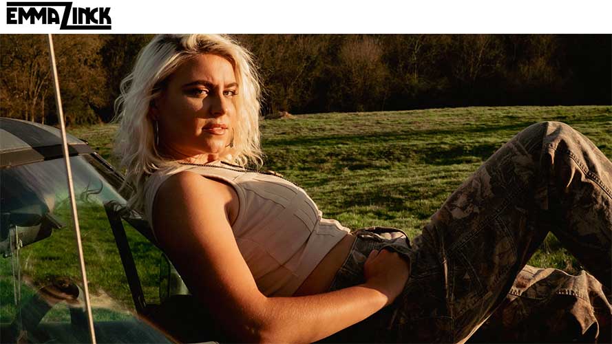 Singer-songwriter Emma Zinck sitting in a chair in a field.
